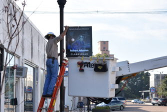 A Clarksdale Public Utilities worker mounts the legendary Robert Johnson sign in front of Cat Head Delta-Blues Folk Art on Delta Avenue.