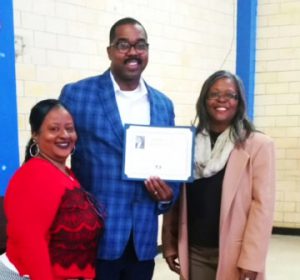 City of Clarksdale Commissioner Willie Turner Jr. holds his "Career Day" certificate from Booker T. Washington school with Ms Joyce Hill, the teacher of the 4th grade class and school principal Brenda Miller.