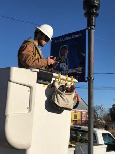 Dylan Doss of Clarksdale Public Utilities mounts Libby Rae's sign.